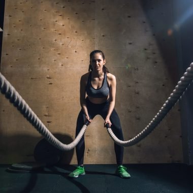 Athletic young woman doing some crossfit exercises with a rope outdoor